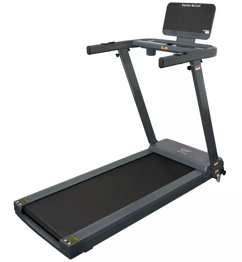 FCSI | A sleek, modern treadmill with a digital console display, safety key, cup holder, and sturdy handrails. The running belt is broad and black, with gray side panels and an adjustable incline. The name "Davina McCall" is visible on the console.