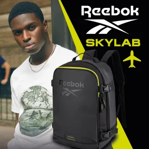FCSI | A man wearing a Reebok t-shirt stands next to a black and green Reebok backpack. The background features the Reebok logo, the word "SKYLAB," and a small airplane graphic.
